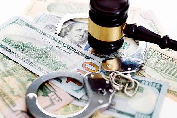Judges gavel and handcuffs on american dollars Judges gavel and handcuffs on american dollars, financial crime concept. money laundering stock pictures, royalty-free photos & images