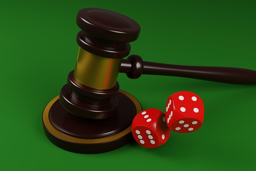 Red dice and judges gavel on a green background 3D render