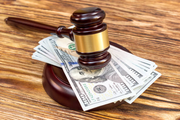 Judge's gavel and stand with US dollar bills on the wooden table. Judge's gavel and stand with US dollar bills on the wooden table. lawsuit stock pictures, royalty-free photos & images