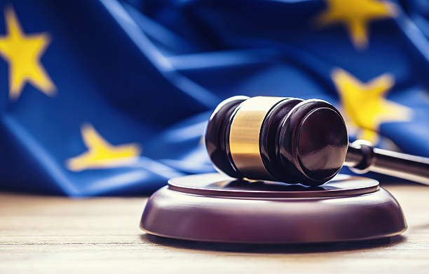 judges wooden gavel with eu flag in the background. - europese unie stockfoto's en -beelden