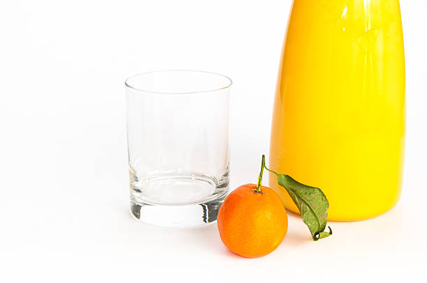 Jug of juice, glass and an orange stock photo