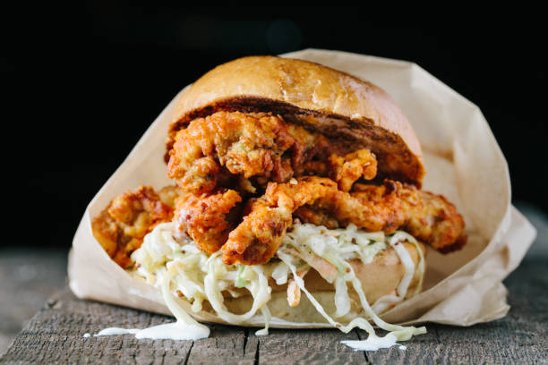 Juicy fried chichen sandwich on a wooden surface Fried crispy chicken sandwich with coleslaw on dark background
horizontal comfort food stock pictures, royalty-free photos & images