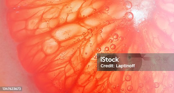 istock juicy red grapefruit slice, abstract wide banner with free space for text 1347623673
