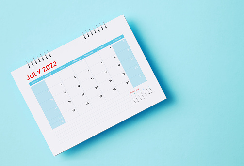 2022 July calendar sitting on aquamarine background. Horizontal composition with copy space. Directly above. Calendar and reminder concept.