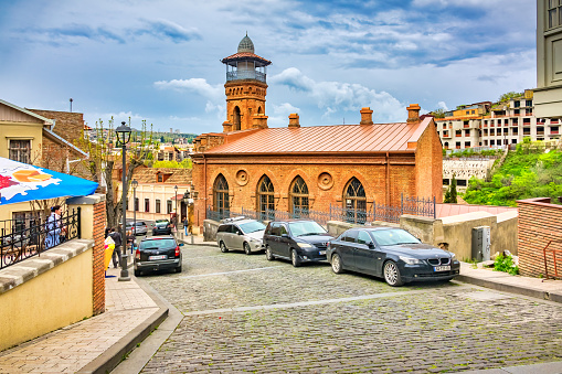 Cars are parked beside the Jumah Mosque in old town Tbilisi, Georgia on a cloudy day.