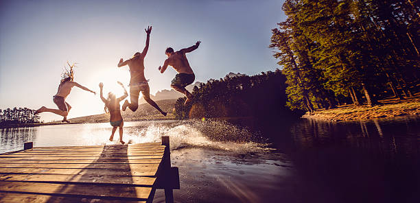 jumping into the water from a jetty - sjö bildbanksfoton och bilder