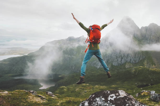 Jumping man in mountains vacations outdoor travel lifestyle adventure hiking vacations active traveler motivation and fun happiness emotions stock photo