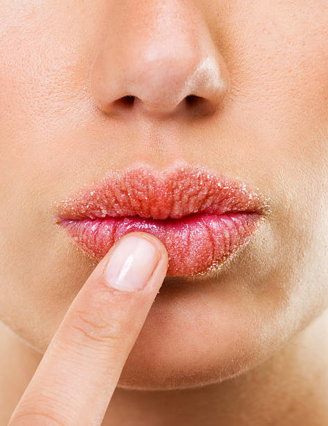 Just a touch of moisture is all she needs Closeup shot of a woman touching her lips human lips stock pictures, royalty-free photos & images