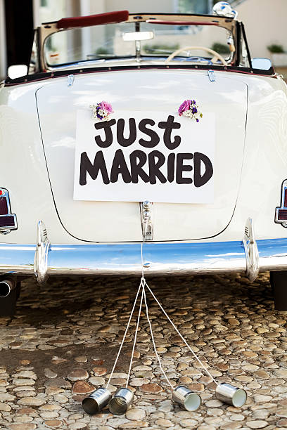 Just Married Sign And Cans Attached On Car's Trunk "Just Married" sign and cans attached on convertible car's trunk. Vertical shot. newlywed stock pictures, royalty-free photos & images