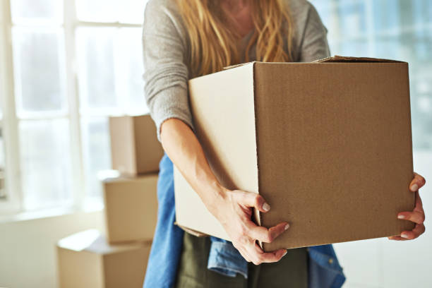 Just one more box and I'm done Cropped shot of a young woman carrying boxes while moving into her new home boxes stock pictures, royalty-free photos & images