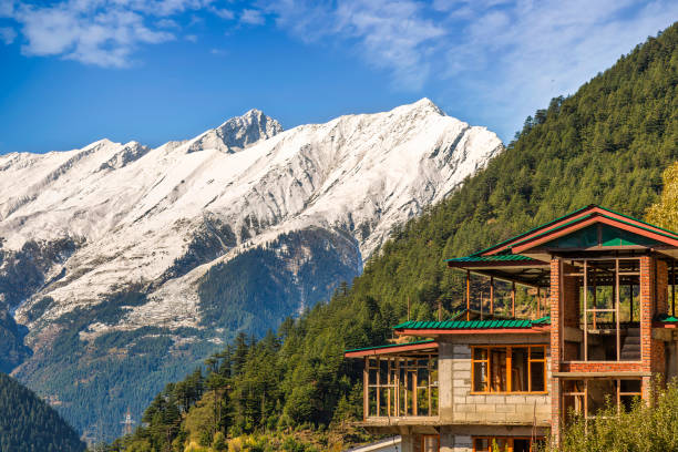 Kailash Himalaya mountain range with under construction tourist hotel on the mountain slopes at Kalpa, Himachal Pradesh, India stock photo