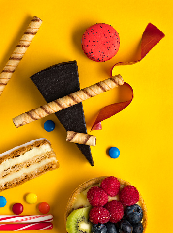 Abstract arrangement of desserts on yellow background
