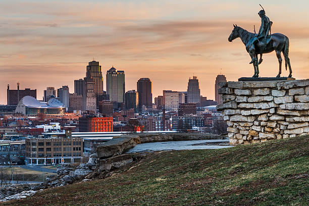Kansas City Scout with View Of Kansas City, Missouri Kansas City, Missouri, USA on March 22, 2014.  A image of the Kansas City Scout overlooking Kansas City at sunrise.  The Indian Scout is known as a Kansas City landmark and symbol of the city. The scout overlooks the Kansas City Skyline. kansas city missouri stock pictures, royalty-free photos & images