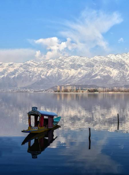 Kashmir: The land of beauty. An empty Shikara on the waters of world famous Dal Lake with a snow-clad mountain at it's backdrop in Srinagar, the summer capital of Indian controlled Kashmir. Kashmir is the model of heaven on Earth and is very popular all over the world for its extravagant beauty. The nature over here gives more peace of mind and the positive energy in oneself, it makes you feel fresh. Kashmir is the land of beauty. An inspiration for so much art, music and poetry, Kashmir is paradise; a nature lover’s wonderland and a shopper’s dream come true. srinagar stock pictures, royalty-free photos & images