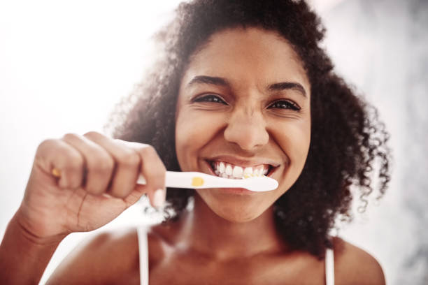 håll tänderna pärlskimrande och ditt leende hälsosamt - kvinna borstar tänderna bildbanksfoton och bilder