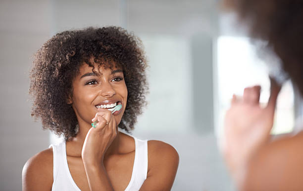 keeping a pearly white smile - kvinna borstar tänderna bildbanksfoton och bilder