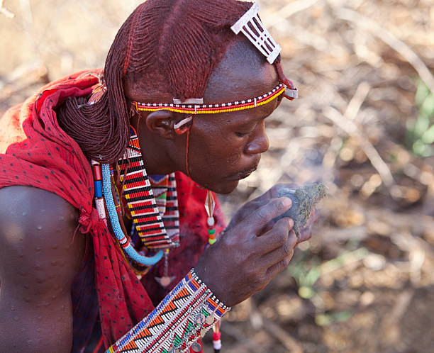 Kenya Masai warrior in traditional dress making fire  masai warrior stock pictures, royalty-free photos & images
