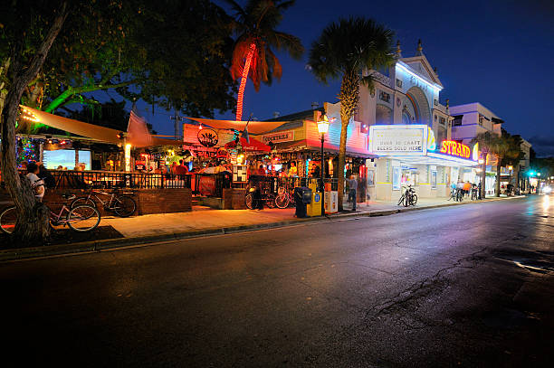 Key West: Willie T's and Duval Street "Key West, Florida, USA - December 3, 2012: Willie T's Bar and festive Duval Street scene complete with lit up shops, neighboring Strand theater, restaurants, traffic, and incidental people sitting in the bar, walking, milling about, etc." mike cherim stock pictures, royalty-free photos & images