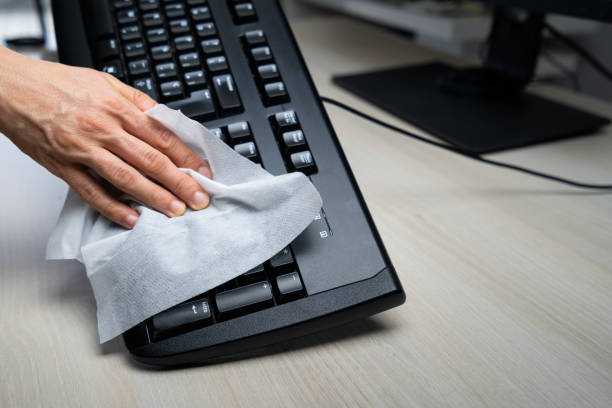 Keyboard being wiped by a person to remove virus and to be protected from the virus during coronavirus pandemic Keyboard being wiped by a person to remove virus and to be protected from the virus during coronavirus pandemic clean desk stock pictures, royalty-free photos & images