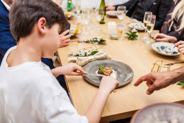 Kid children eating octopus at private dinner at home stock photo