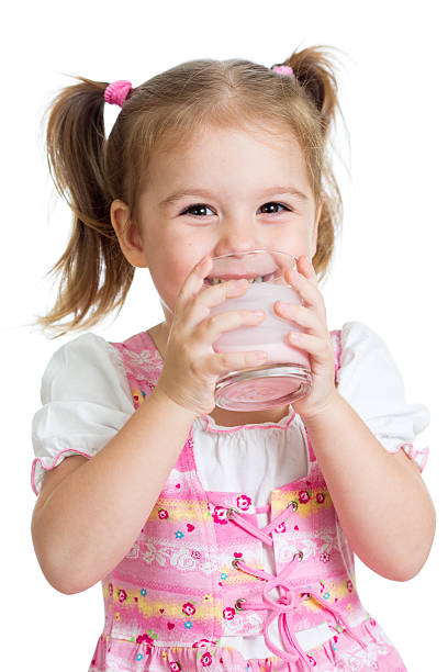 Kid drinking yoghurt from glass stock photo