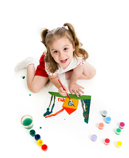 Kid girl is painting. Top view. stock photo