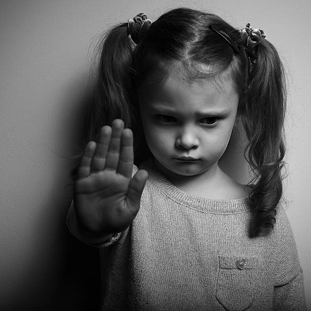 Kid girl showing hand signaling to stop violence stock photo