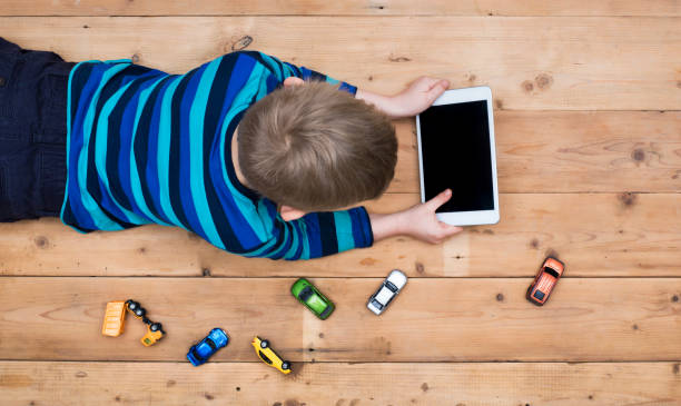 kid on floor with tablet pc stock photo
