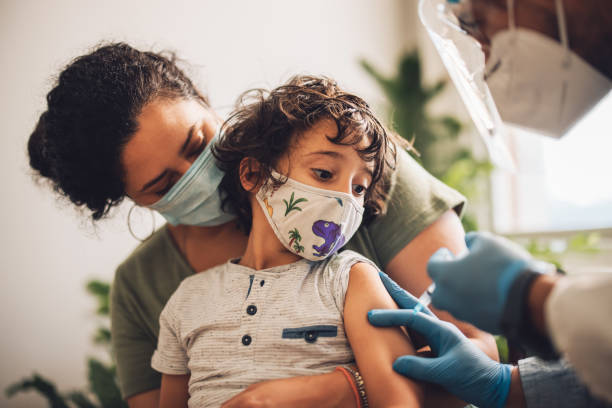 niño que recibe la vacuna contra el covid en casa - niño fotografías e imágenes de stock
