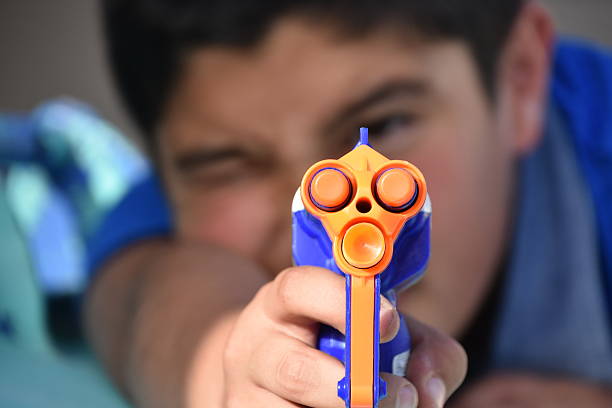 Kid shooting a toy gun stock photo