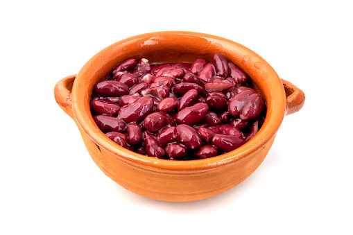 Kidney beans in a terracotta bowl on a white background