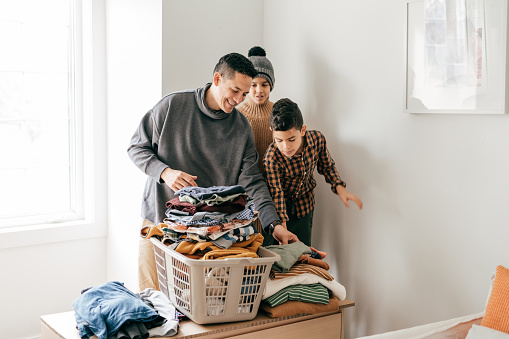Kids and dad folding laundry together