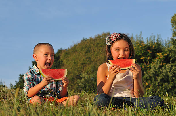 Kids eating sliced Watermelon stock photo