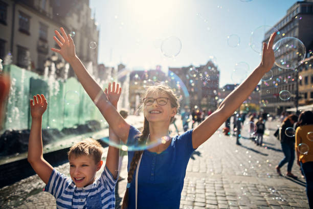 Kids enjoying bubbles in Market Square in Wrocław, Poland Two kids enjoying bubbles in the air while sightseeing Wrocław, Poland. 
Nikon D850 wroclaw photos stock pictures, royalty-free photos & images
