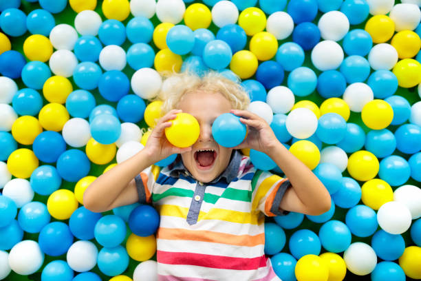 Kids play in ball pit. Child playing in balls pool Child playing in ball pit. Colorful toys for kids. Kindergarten or preschool play room. Toddler kid at day care indoor playground. Balls pool for children. Birthday party for active preschooler. indoor playground stock pictures, royalty-free photos & images