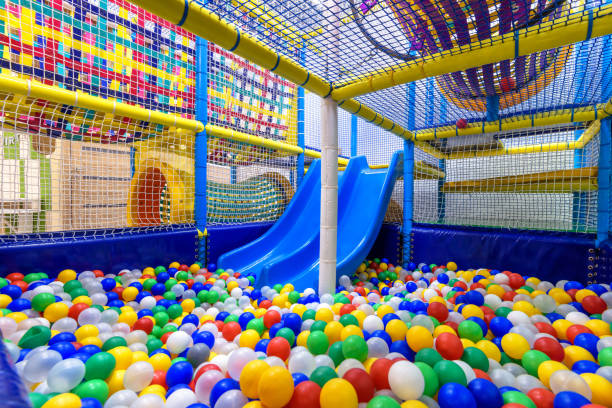 Kids playground indoor. Panoramic view inside the dry pool with colorful balls and slide. Nice plastic gym for activity in playroom. Kids playground indoor. Panoramic view inside the dry pool with colorful balls and slide. Nice plastic gym for activity in playroom. Children playground for sport and play in kindergarten. indoor playground stock pictures, royalty-free photos & images
