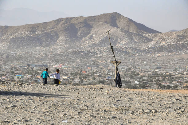 kids playing on the sandy hills over Kabul city stock photo