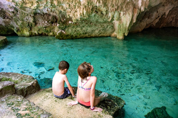 Kids swimming in cenote in Cancun stock photo