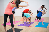 Kids yoga and stretching with instructor in gymnasium