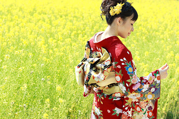 Kimono Woman in Canola Field Woman wearing Japanese kimono in Canola Field. furisode stock pictures, royalty-free photos & images