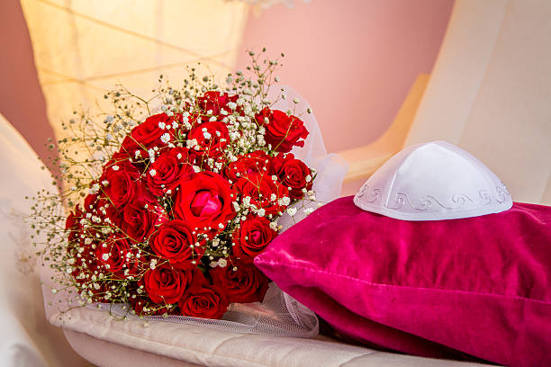 Kippah and bouquet with red roses Jewish wedding - Kippah of groom and bouquet with red roses of bride ketubah stock pictures, royalty-free photos & images