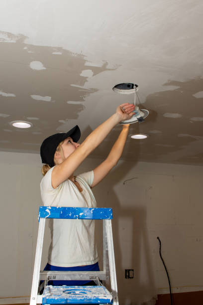 Kitchen Remodel Young Woman Installing Ceiling Light stock photo