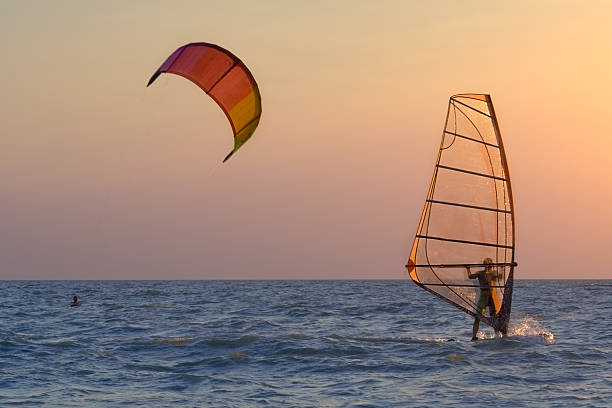 Kite-surfing and windsurfing at the sunset stock photo
