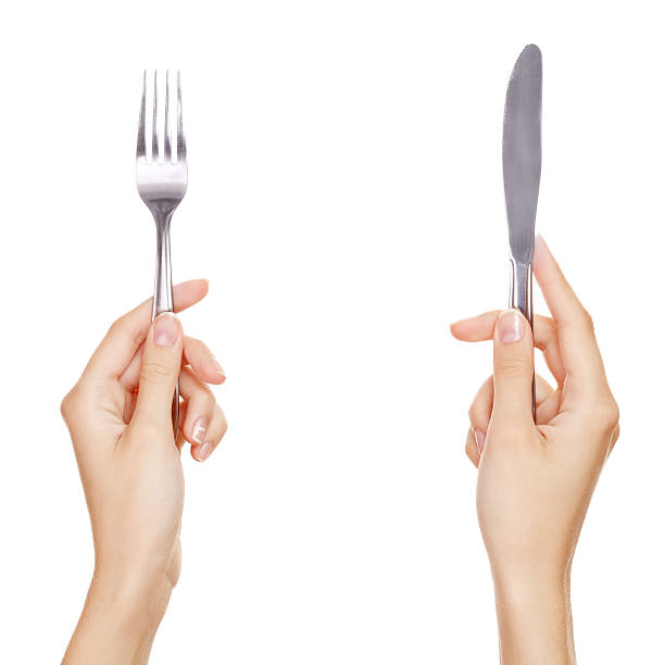 knife and fork being held by womans hands. Isolated stock photo