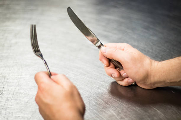 Knife and fork in hands waiting for food. stock photo