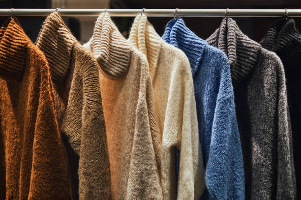 Knitted winter pullovers on a rack stock photo
