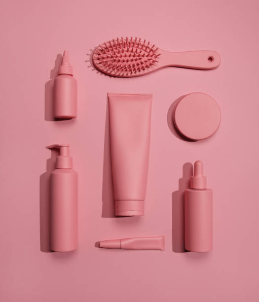 Flat lay photo of hand-painted beauty products in monochrome pink color