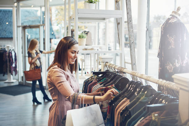 I know I'll find something I like here Shot of a young woman shopping at a clothing store clothing store photos stock pictures, royalty-free photos & images