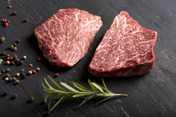Kobe beef filet with pepper and rosemary on black background stock photo