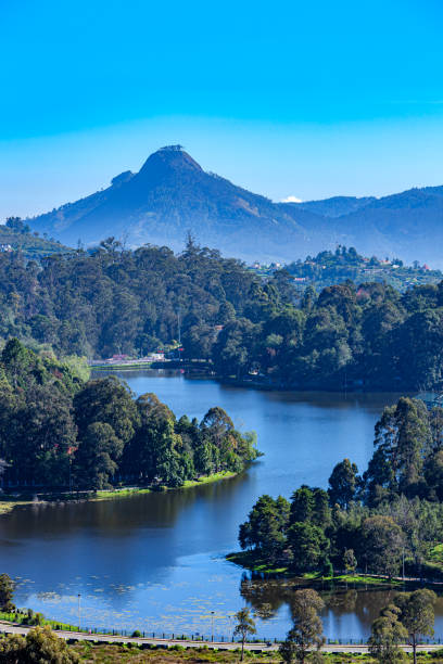 Kodaikanal, South India - Looking Down At Kodaikanal Lake From A Higher Elevation In The Colonial Town, In The State Of Tamil Nadu; In The Far Background Is The Peak Known Locally As Perumal Malai. No people. stock photo